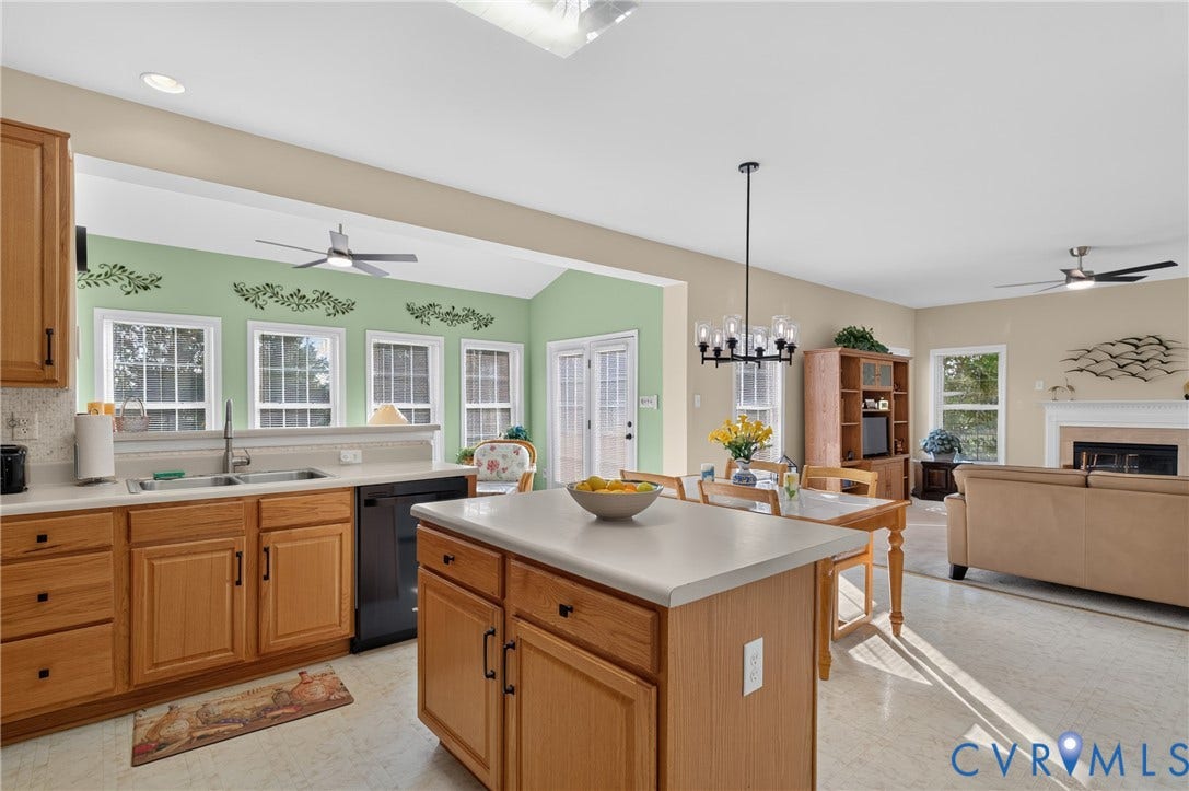 10817 Correnty Drive, Glen Allen, VA 23059 Open-concept kitchen featuring light wood cabinetry, a central island with a solid surface countertop, and a double basin sink
