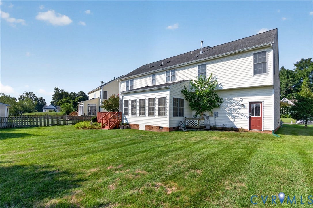 10817 Correnty Drive, Glen Allen, VA 23059 Expansive grassy yard featuring a white picket fence, sunroom, wood deck, and an exterior side door
