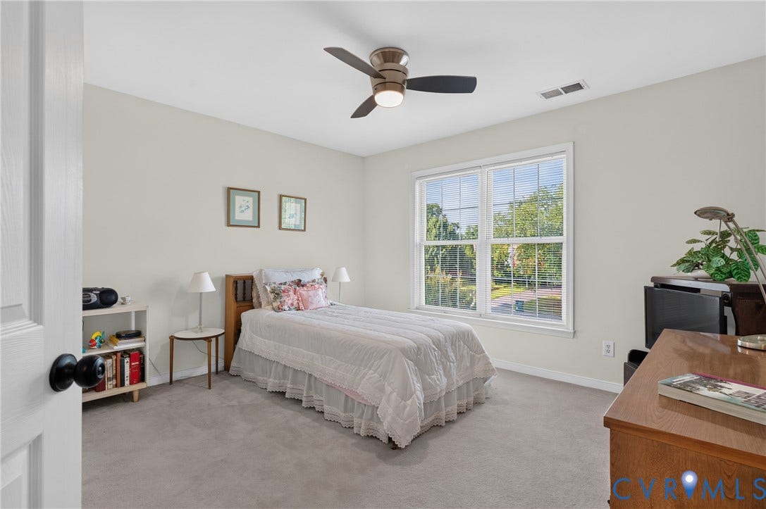 10817 Correnty Drive, Glen Allen, VA 23059 Light-filled room featuring a large window, neutral wall tones, gray carpeting, a ceiling fan, and white trim