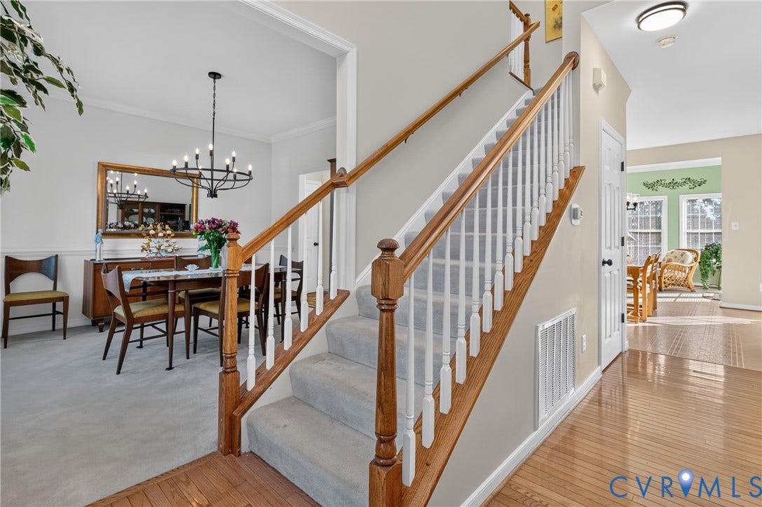 10817 Correnty Drive, Glen Allen, VA 23059 Entryway featuring wood-finish flooring, a carpeted staircase with wood handrails and white balusters, and crown molding