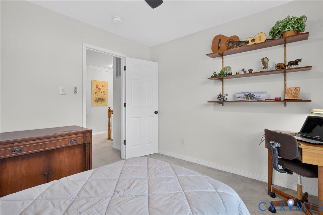 10817 Correnty Drive, Glen Allen, VA 23059 Carpeted room with light neutral wall paint, featuring a ceiling fan and a white paneled door