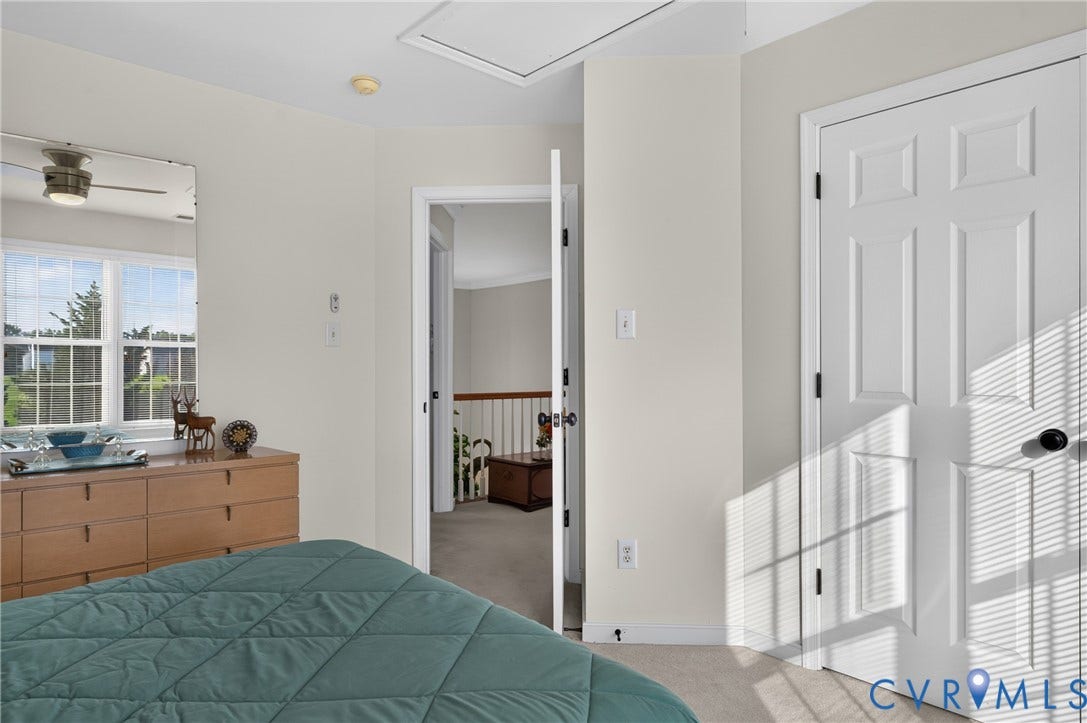 10817 Correnty Drive, Glen Allen, VA 23059 Carpeted room featuring a white interior door with black hardware, a multi-pane window, and a ceiling-mounted fan with light fixture