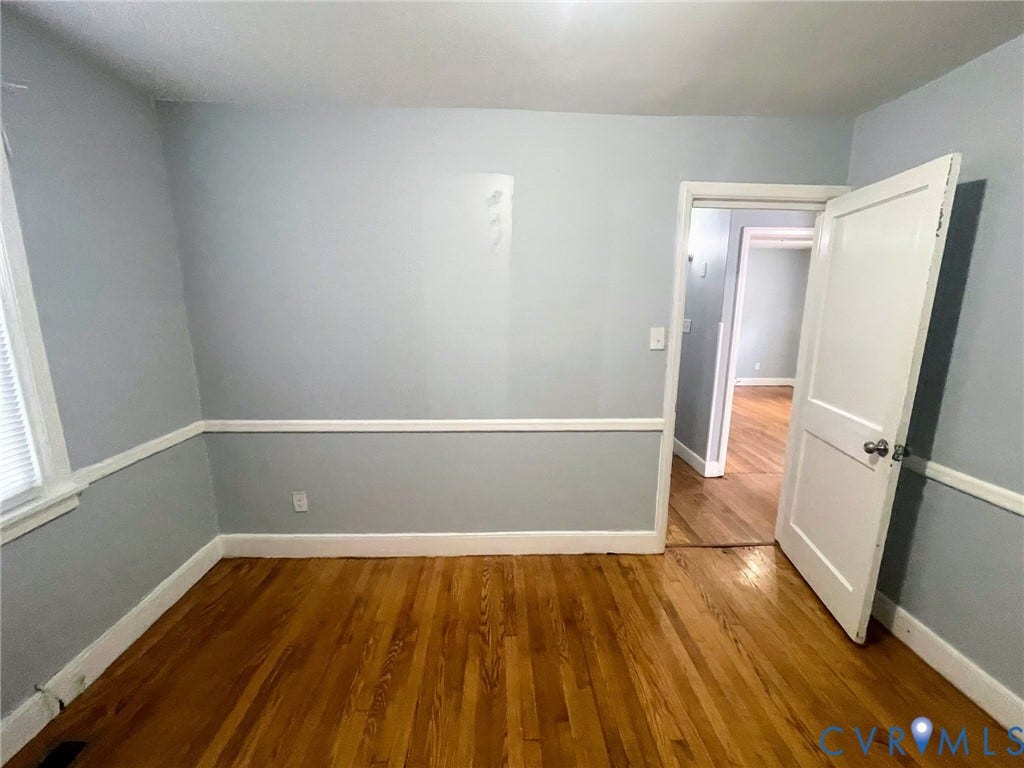 1417 Bowen Street, Oak Grove, Richmond, VA 23224 Hardwood flooring featured throughout this room, with light-toned wall paint & chair rail molding