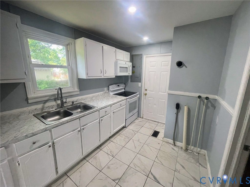 1417 Bowen Street, Oak Grove, Richmond, VA 23224 Kitchen featuring white cabinetry, a double basin stainless steel sink, a white electric range, and white tiled flooring. Also has washer/dryer hookup.