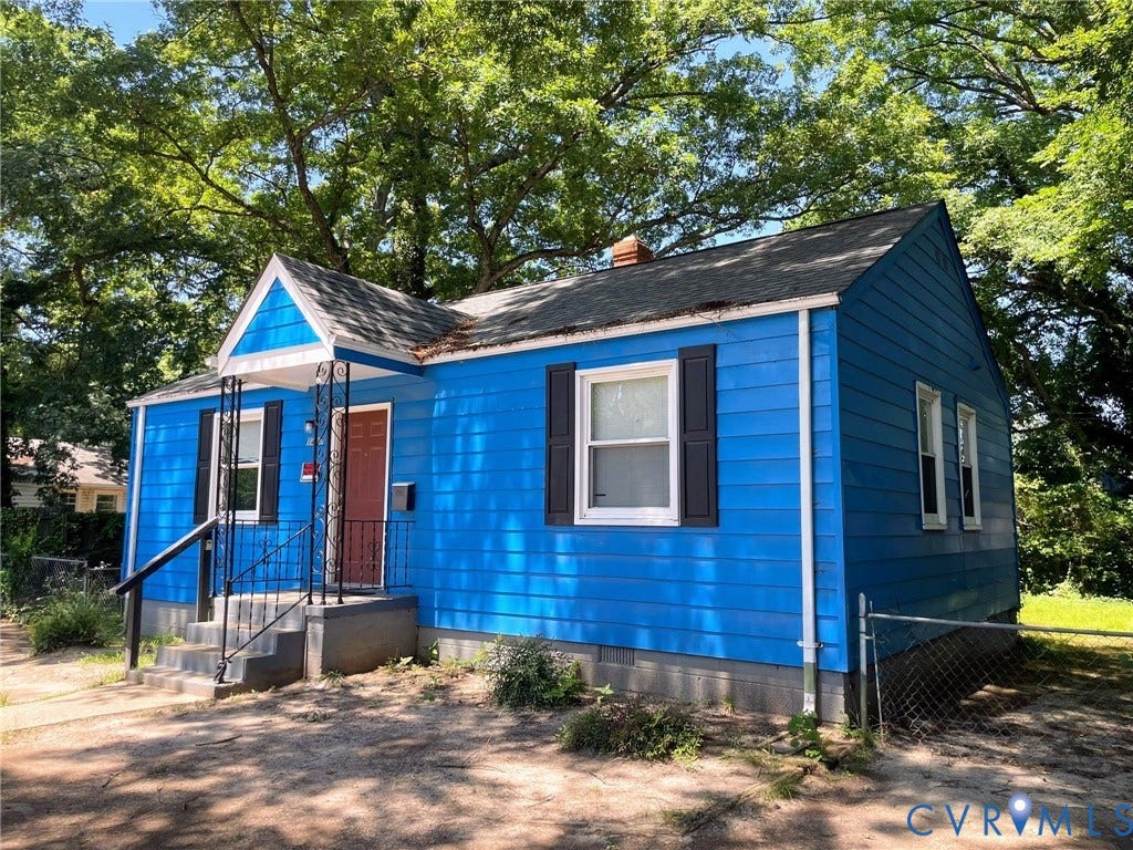 1417 Bowen Street, Oak Grove, Richmond, VA 23224 Blue exterior siding with contrasted dark shutters, front porch with wrought iron railings, and a red front door