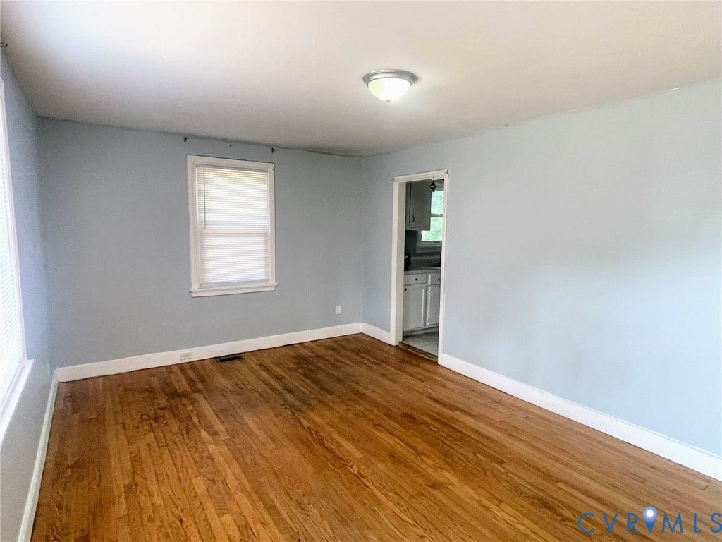 1417 Bowen Street, Oak Grove, Richmond, VA 23224 Spacious living room featuring wood flooring, neutral paint colors, white trim, and multiple windows with blinds