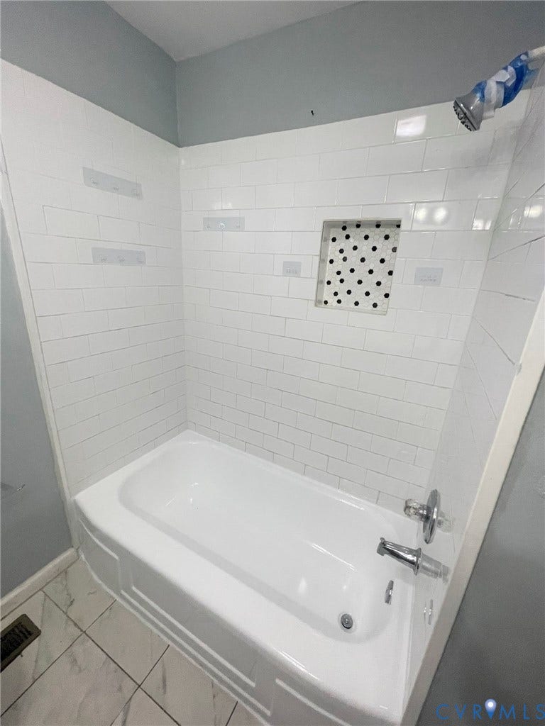 1417 Bowen Street, Oak Grove, Richmond, VA 23224 Recently refinished bathtub with white subway tile surround, built-in shower shelving, and chrome colored fixtures