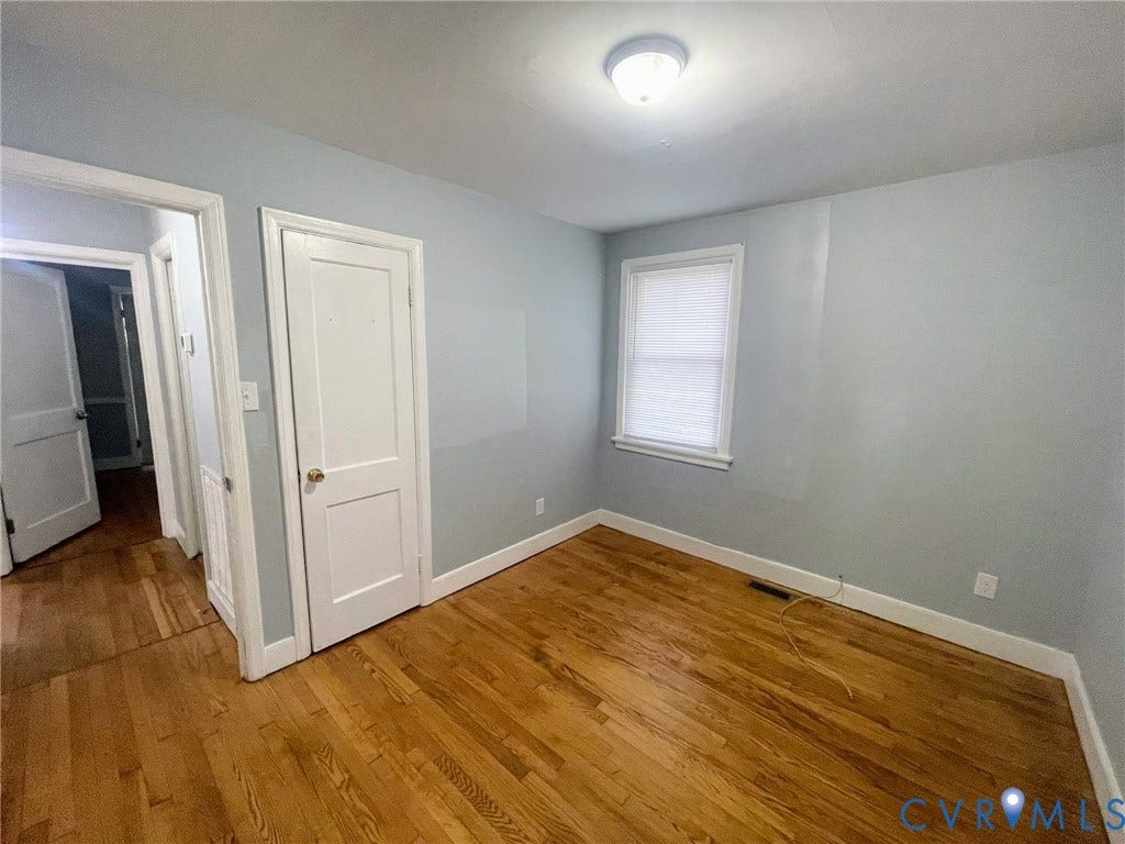 1417 Bowen Street, Oak Grove, Richmond, VA 23224 Hardwood flooring throughout, light blue wall paint, white trim, and a ceiling-mounted light fixture