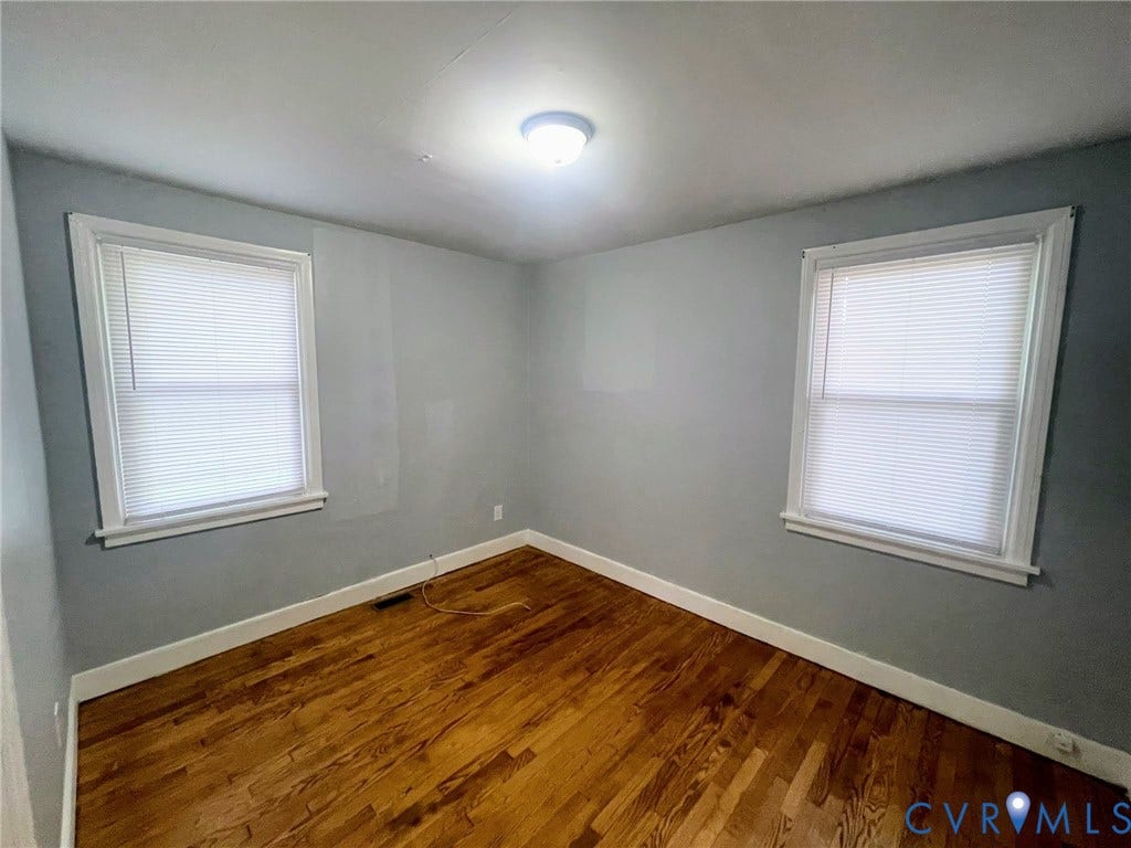 1417 Bowen Street, Oak Grove, Richmond, VA 23224 Room featuring two windows with blinds, wood flooring, and a flush-mount ceiling light fixture