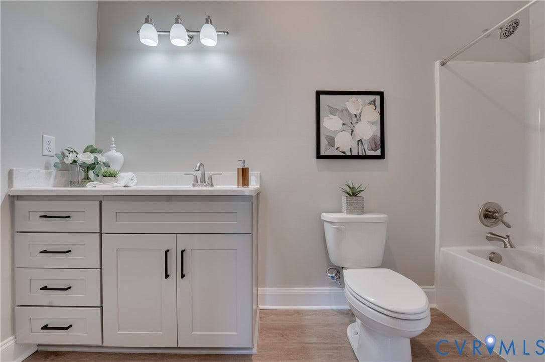 6408 Sanford Springs Cove, Midlothian, VA 23112 Bathroom featuring a light gray vanity with black hardware, white countertop, and a built-in tub with a shower