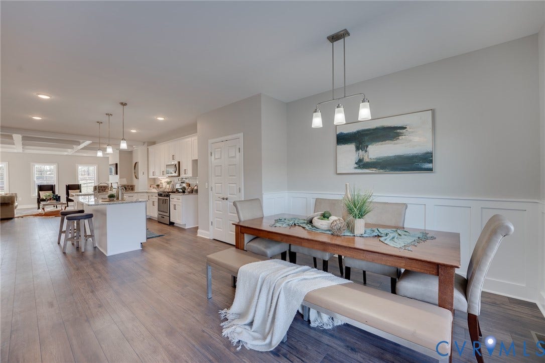 6408 Sanford Springs Cove, Midlothian, VA 23112 Open-concept interior featuring wood-finish flooring, white wainscoting, and a linear pendant light fixture