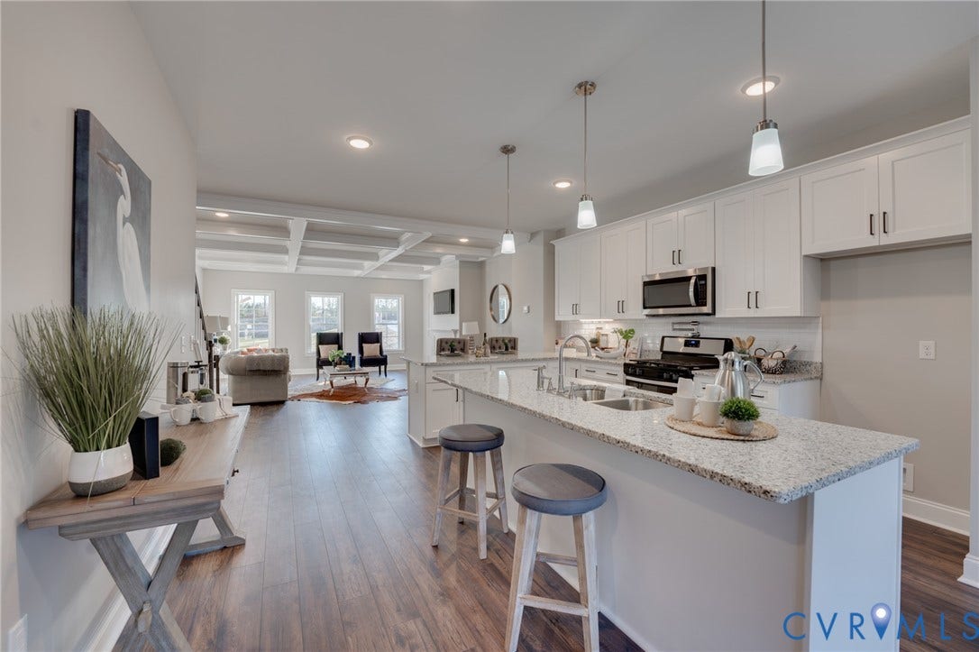 6408 Sanford Springs Cove, Midlothian, VA 23112 Bright kitchen featuring white cabinetry, stainless steel appliances, and a spacious island with granite countertops