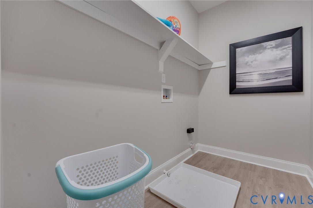 6408 Sanford Springs Cove, Midlothian, VA 23112 Dedicated laundry area featuring a wall-mounted shelf, light gray wall paint, and wood-finish flooring with white baseboards