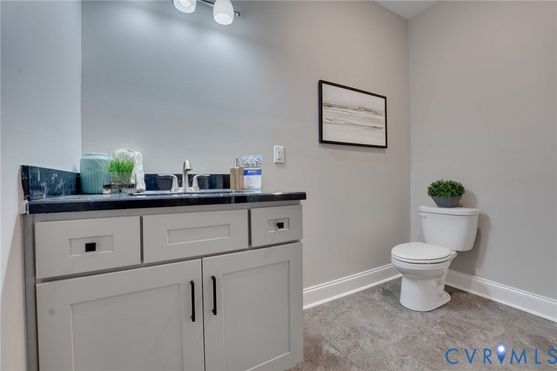 6408 Sanford Springs Cove, Midlothian, VA 23112 Bathroom featuring a light grey vanity with black hardware, a black countertop, and a white toilet