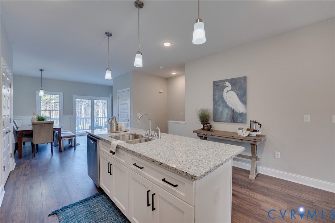 6408 Sanford Springs Cove, Midlothian, VA 23112 Kitchen island featuring a dual-basin stainless steel sink, a gooseneck faucet, and integrated dishwasher