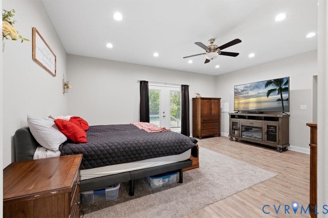 Spacious room featuring light wood-finish flooring, recessed lighting, and a ceiling fan with integrated light