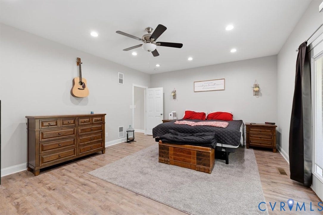 Spacious room featuring wood-finish flooring, recessed ceiling lighting, a ceiling fan, and light gray wall paint