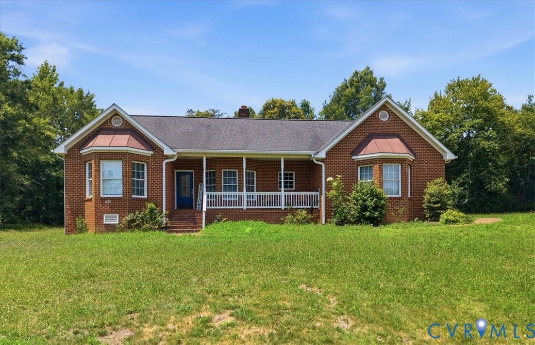 Brick exterior with a covered front porch featuring white railing and columns