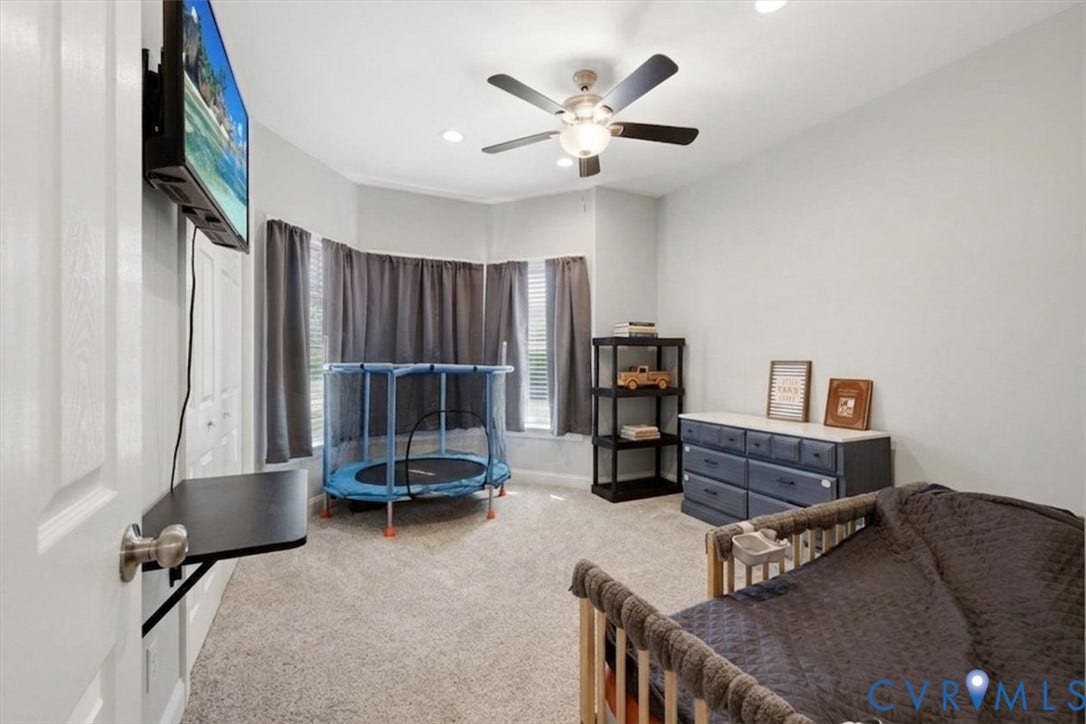 Carpeted interior space featuring a multi-window bay, recessed lighting, and a ceiling fan