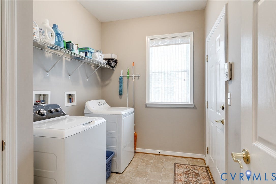 Laundry Room Featuring Tile Flooring, Washer/Dryer, and Wire Shelving for Extra Storage.