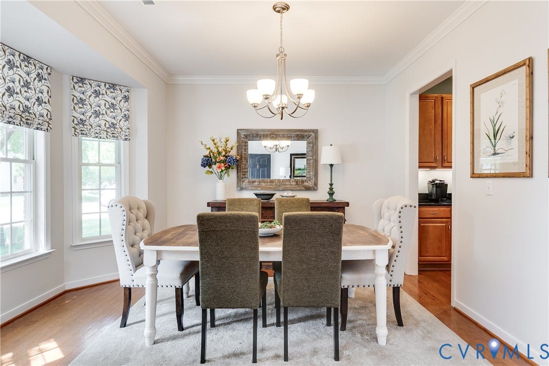 Dining Room Featuring Hardwood Flooring and Tray Ceiling.