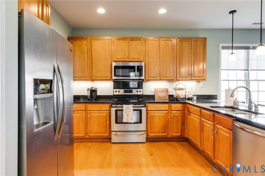 Large Kitchen Featuring Hardwood Flooring, Custom Cabinets, and Recessed Lighting.