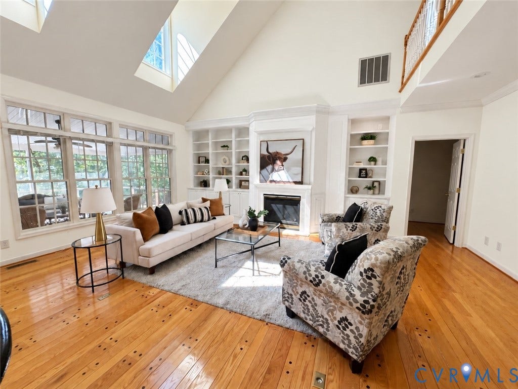 2065 Garrett Lane, Powhatan, VA 23139 AI generated photo showing the living room walls painted and the built in/mantel cabinet painted white to show that paint could update look.