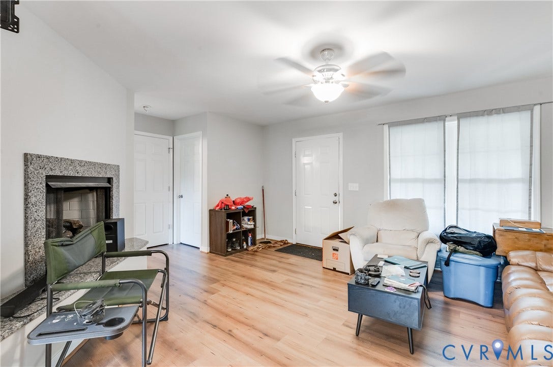 24580 St James Road, Amelia, VA 23083 Spacious living area featuring wood-finish flooring, a ceiling fan with integrated lighting, and multiple windows providing natural light