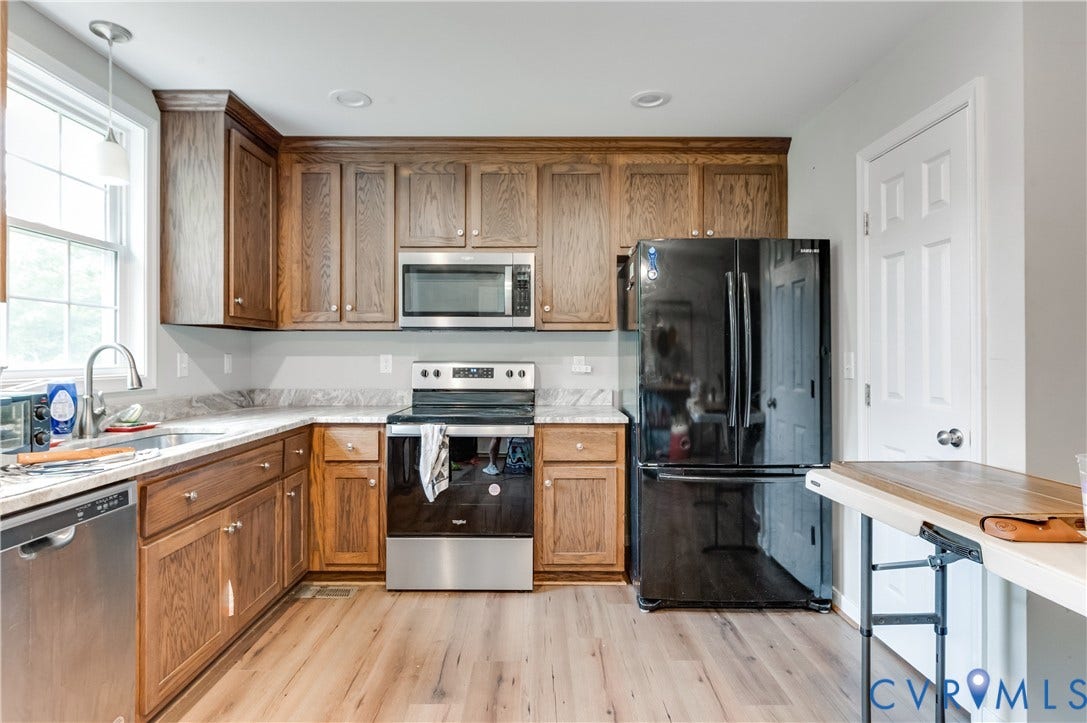 24580 St James Road, Amelia, VA 23083 Kitchen featuring wood-finish cabinetry, light-toned countertops, and stainless steel appliances