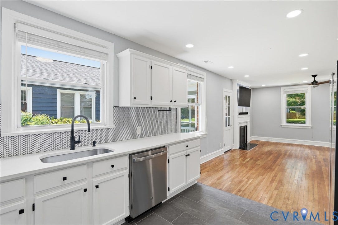 6929 Woodrow Terrace, Richmond, VA 23228 Kitchen featuring white cabinetry, solid surface countertops, a stainless steel undermount sink with a matte black faucet, and hexagonal mosaic tile backsplash