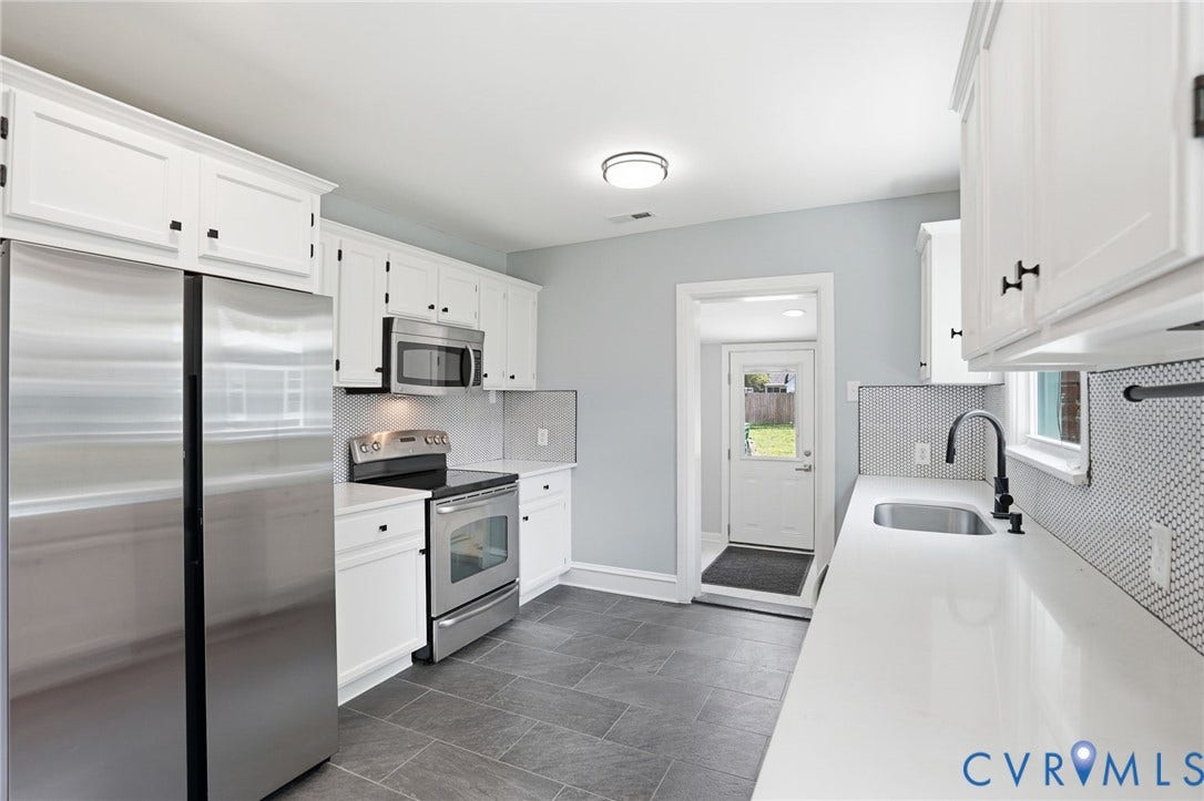 6929 Woodrow Terrace, Richmond, VA 23228 Kitchen featuring white cabinetry with black hardware, stainless steel appliances, solid surface countertops, a mosaic tile backsplash, and dark tile flooring