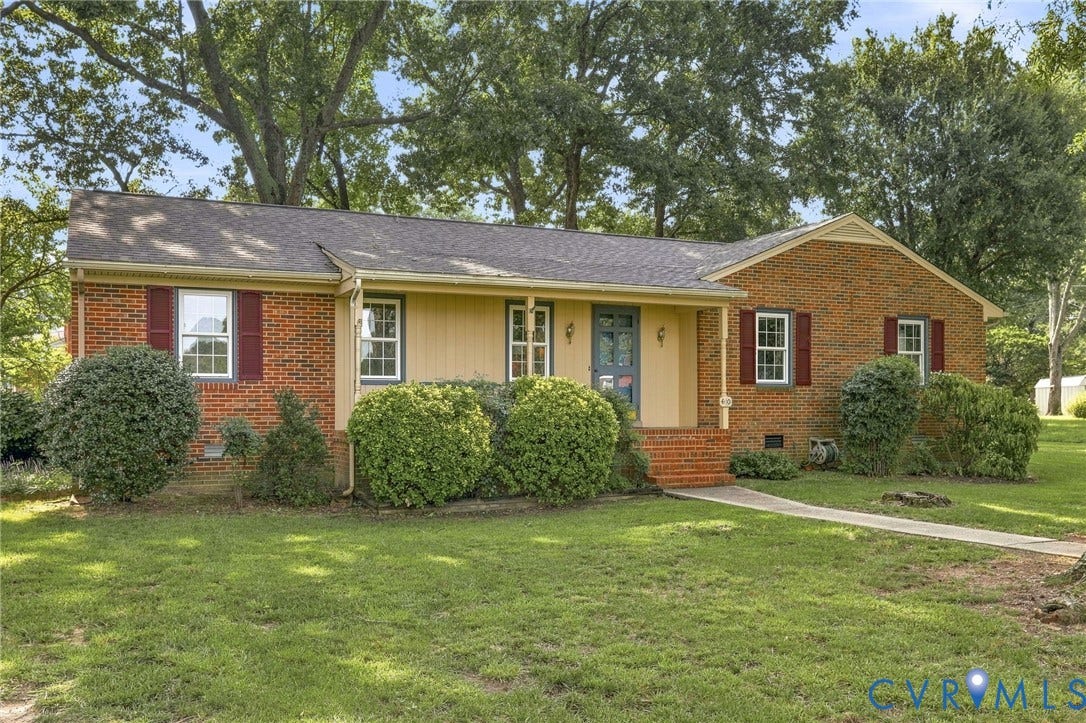 4001 Saldale Drive, North Chesterfield, VA 23237 Hardwood flooring, brick fireplace with mantel, white paneling, built-in shelving, and a ceiling fan