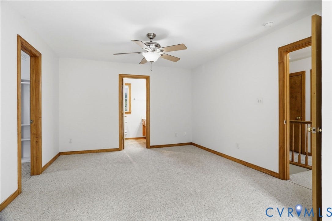 Carpeted room with white walls and natural wood trim