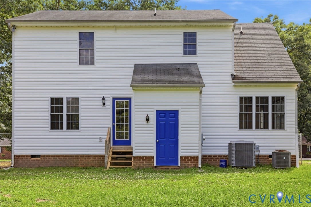 White vinyl siding exterior with two blue doors, one featuring a multi-pane glass insert