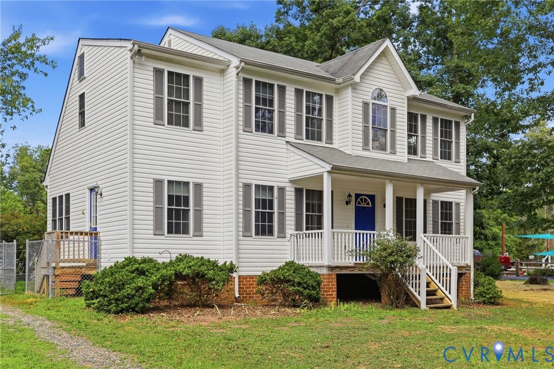 Two-story residence featuring white siding, a covered front porch with white railings, and a blue front door