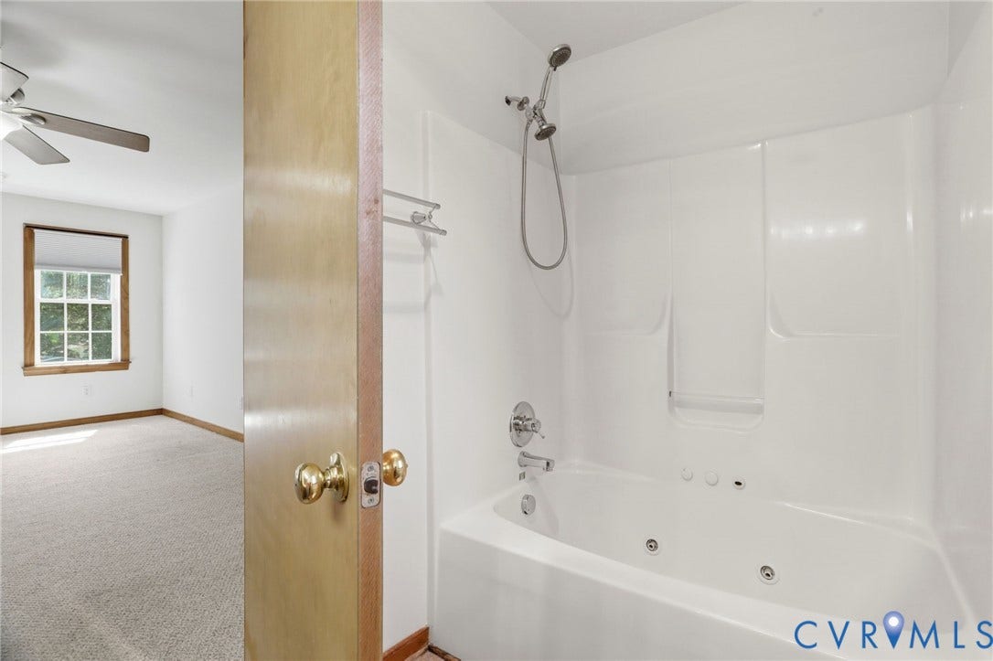 White jetted tub and shower combination with chrome fixtures