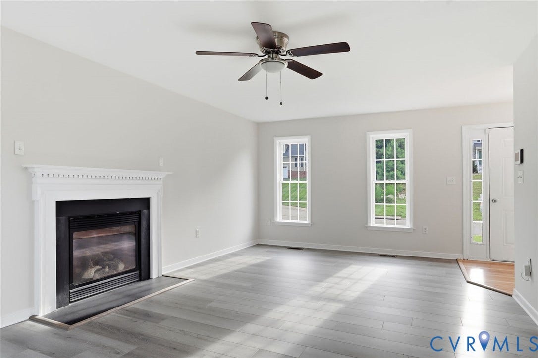 6412 Autumn Mist Way, Chesterfield, VA 23832 Spacious interior featuring a white mantel fireplace with black insert, wood-finish flooring, and multiple windows