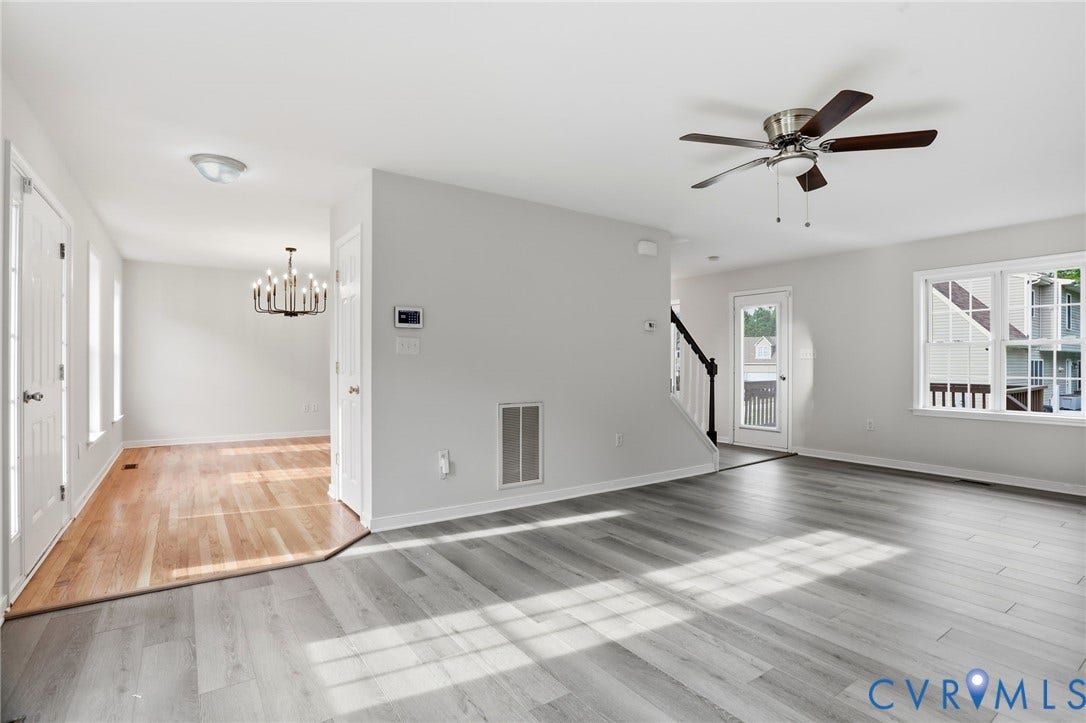 6412 Autumn Mist Way, Chesterfield, VA 23832 Spacious living area featuring light gray wood-finish flooring, a contemporary ceiling fan, and large windows