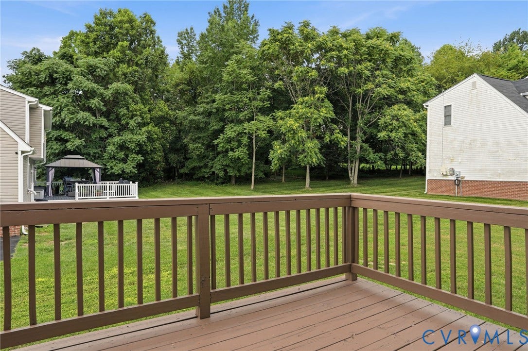 6412 Autumn Mist Way, Chesterfield, VA 23832 Expansive wooden deck with coordinating railings, overlooking a grassy yard bordered by mature trees