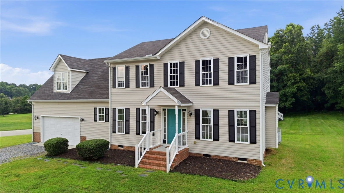 6412 Autumn Mist Way, Chesterfield, VA 23832 Traditional two-story home featuring light-colored siding, black louvered shutters, an attached two-car garage, and a welcoming front porch with a vibrant turquoise door