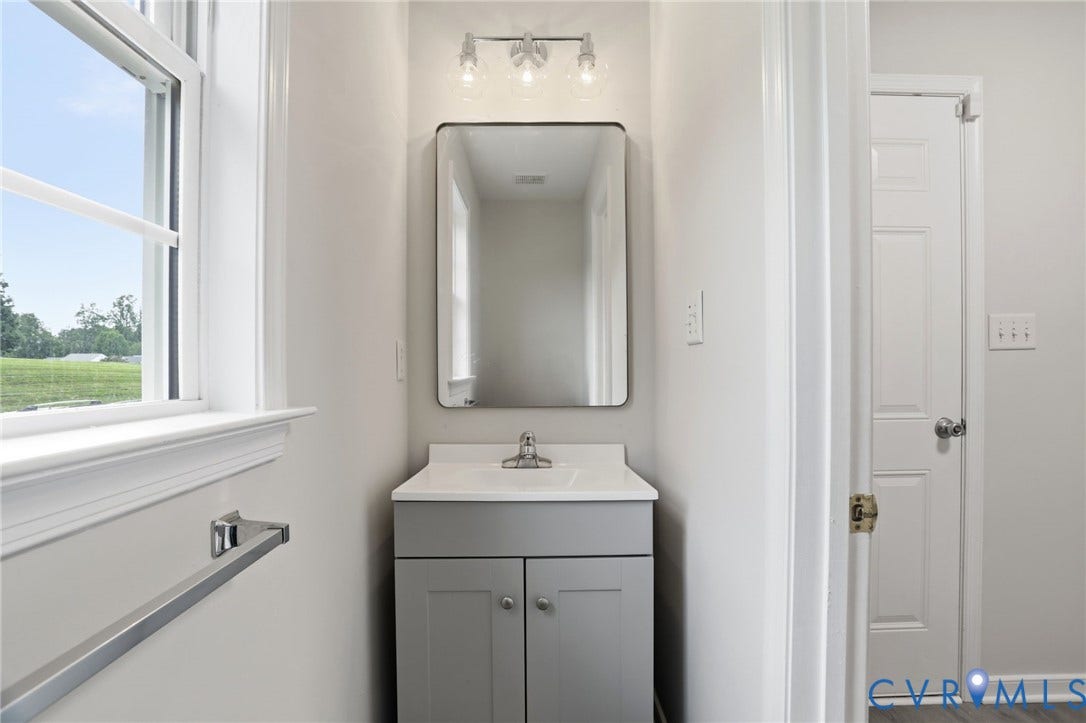 6412 Autumn Mist Way, Chesterfield, VA 23832 Bathroom vanity featuring a light gray cabinet base with brushed nickel hardware, a white countertop, and a rectangular mirror with integrated lighting