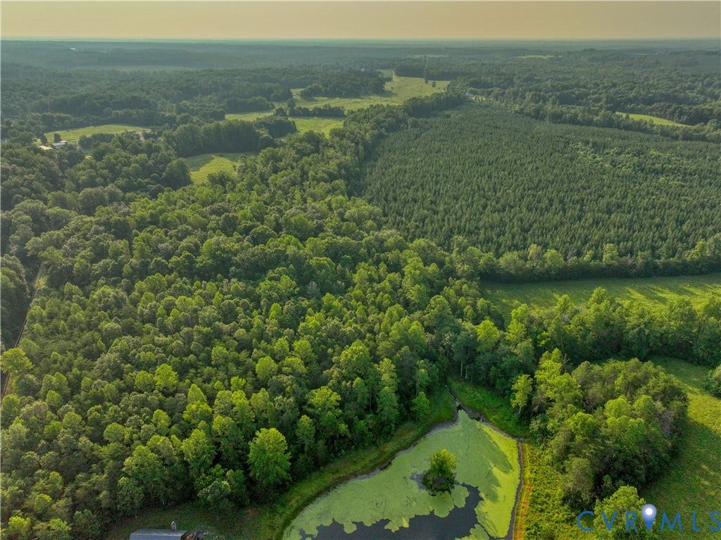 Expansive aerial of verdant woodlands and open fields