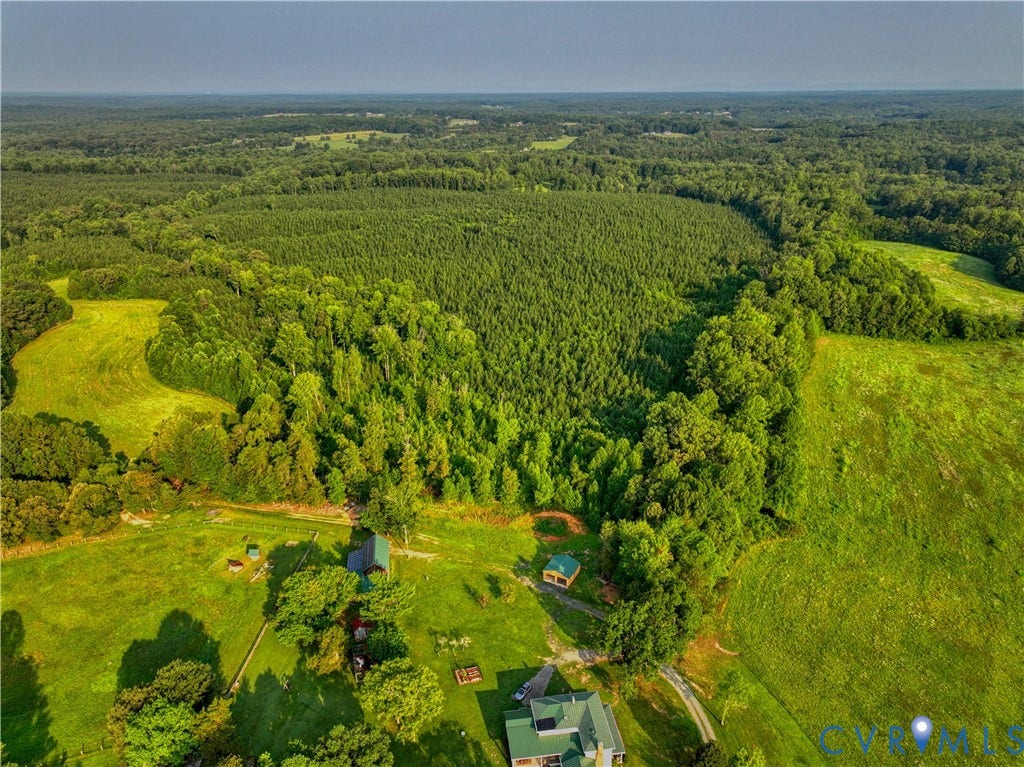 Expansive wooded and cleared acreage featuring mature trees and open fields