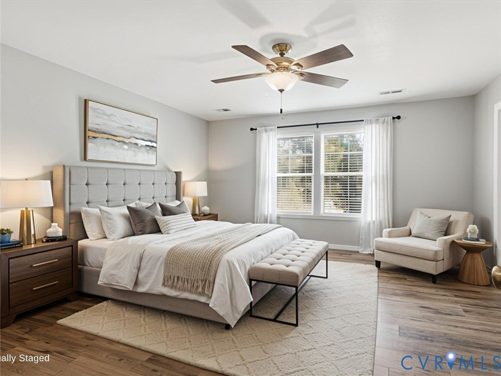 17431 Memorial Tournament Drive, Wynstone Park, Moseley, VA 23120 Escape to the expansive primary suite, thoughtfully designed with luxury vinyl plank flooring, oversized windows that fill the room with natural light, a ceiling fan, and ample space for a cozy reading nook or seating area. The oversized walk-in closet offers abundant storage, while the luxurious en-suite bath features a dual vanity and an oversized tiled walk-in shower with a built-in bench, creating the perfect spa-inspired retreat