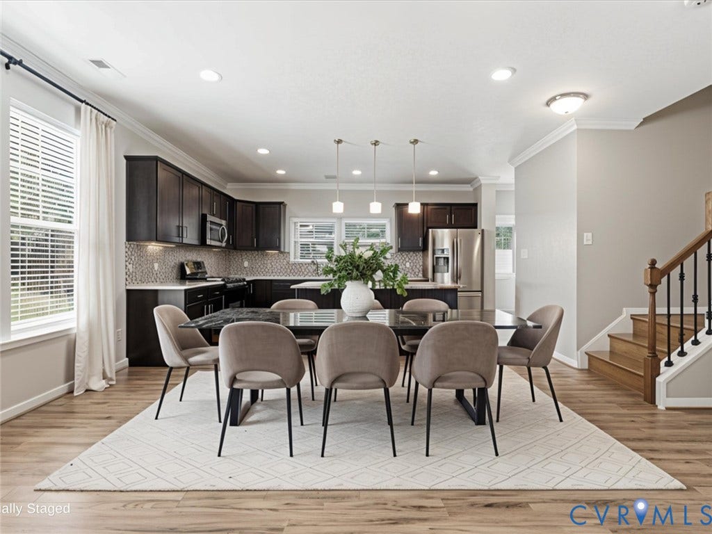 17431 Memorial Tournament Drive, Wynstone Park, Moseley, VA 23120 The spacious dining area seamlessly connects to the kitchen, creating an ideal setting for everyday meals or entertaining. Highlighted by luxury vinyl plank flooring, elegant crown molding, and abundant natural light, it comfortably accommodates a large dining table while maintaining the home's open-concept design