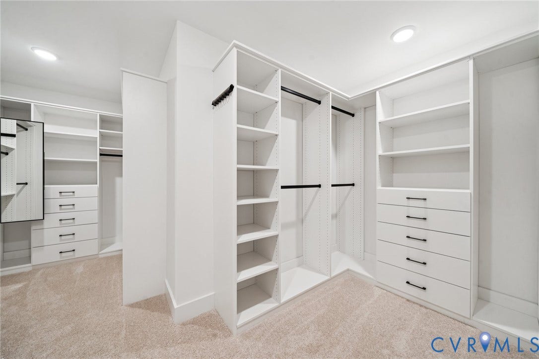 9156 Terroir Lane, Viniterra Villas, New Kent, VA 23124 Custom closet system featuring extensive shelving, built-in drawers with modern hardware, multiple hanging rods, and recessed lighting