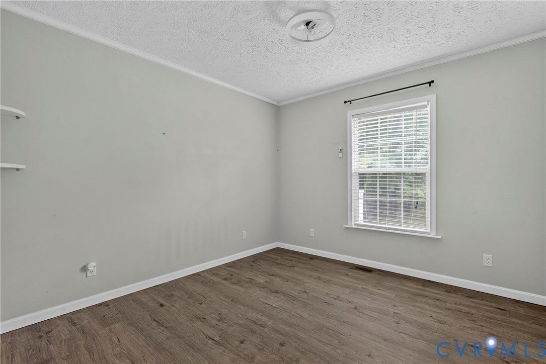 4106 S Spotswood Trail, Trevilians, Louisa, VA 22942 Neutral-toned room featuring wood-finish flooring, white baseboards, and a single window with white blinds