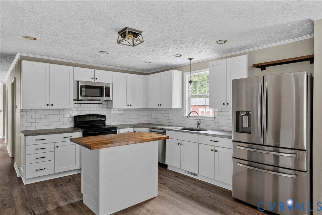 4106 S Spotswood Trail, Trevilians, Louisa, VA 22942 Modern kitchen featuring white shaker cabinetry, stainless steel appliances, speckled countertops, a subway tile backsplash, and wood-finish flooring
