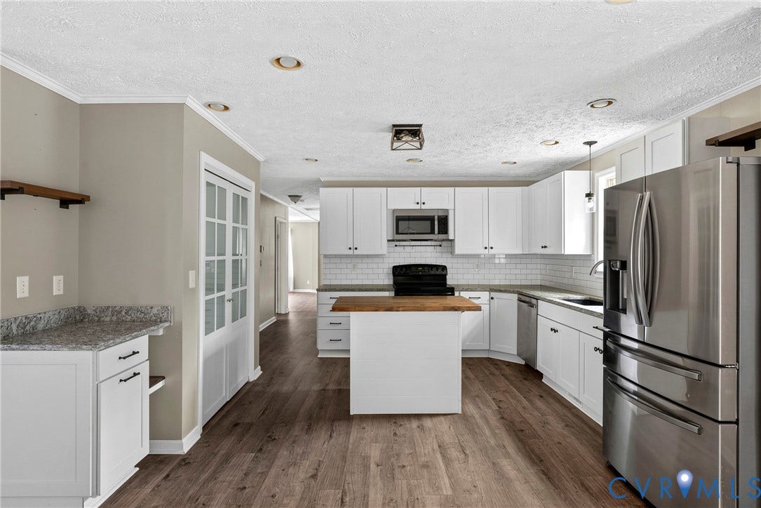 4106 S Spotswood Trail, Trevilians, Louisa, VA 22942 Open kitchen featuring white cabinetry, subway tile backsplash, stainless steel appliances, and a central island with a wood-finish countertop