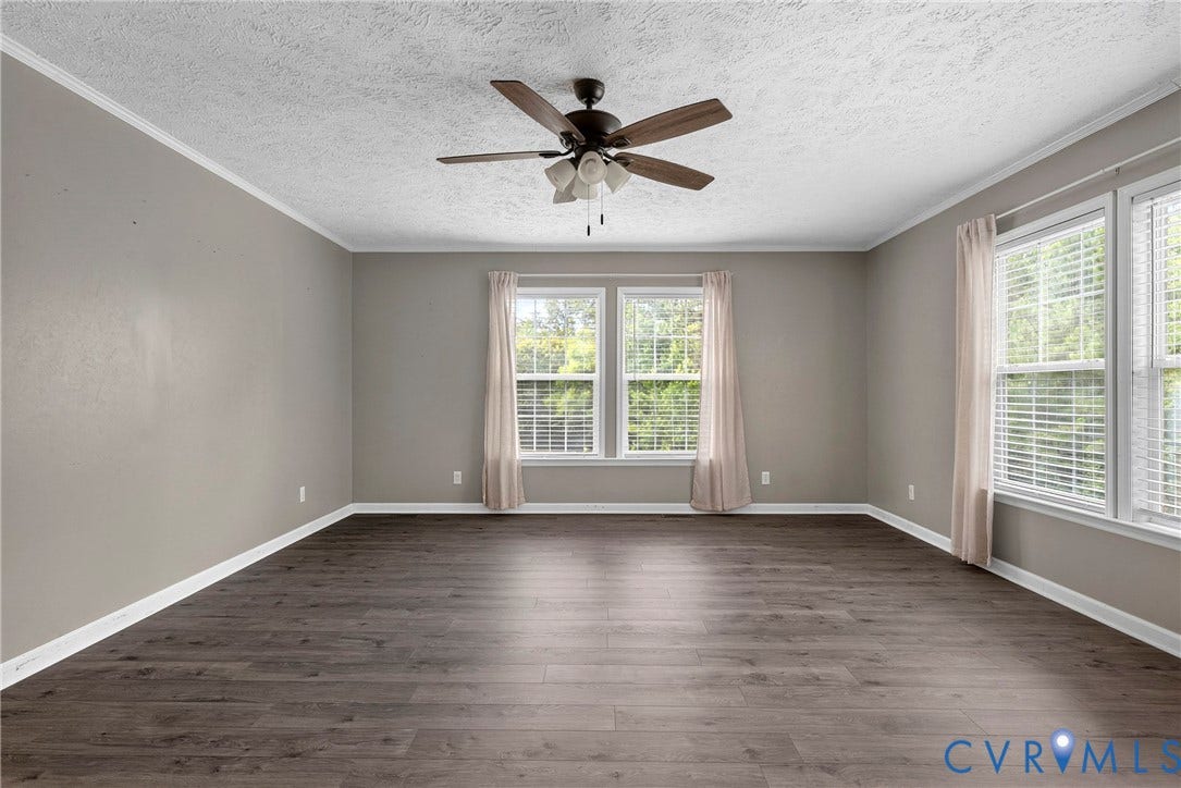 4106 S Spotswood Trail, Trevilians, Louisa, VA 22942 Spacious room featuring dark wood-finish flooring, light gray wall paint, white trim, and a ceiling fan with integrated lighting
